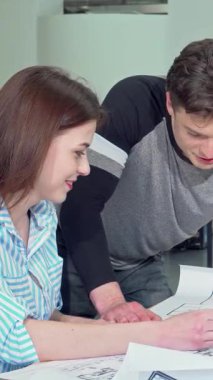 Neşeli bir kadın mimar ve özenli erkek meslektaşı şık, modern bir ofis masasının ayrıntılı planlarına daldılar. Sinerjileri yaratıcılığı ve yeniliği ateşledi. Bu canlı sahne, mimaride takım çalışmasının özünü yakalar.