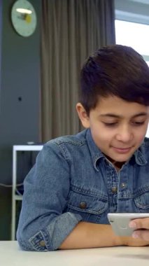 Koyu renk saçlı keyifli bir genç çocuk babasının telefonunda canlı görüntülerde geziniyor dijital macerayla meşgul. Yakışıklı Afrikalı Amerikalı baba, oğluyla son moda, modern zamanlarını paylaşıyor.