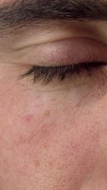 Neşeli bir adamın yakın çekimi, mutluluk ve kendine güvenle parıldayan çarpıcı yeşil gözlerini gözler önünde sergiliyor. Yumuşak ışık, onun gevşek ifadesini, davetkar bağlantısını ve iyimserlik ve cazibe duygusunu vurgular.