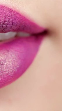 Bu çekici makro çekim, zengin erik dudaklar arasına yerleştirilmiş, hafifçe ayrılmış, parlak beyaz dişleri olan bir kadının ağzını yakalıyor. Işıl ışıl sarı bir zemin üzerine kurulmuş bu görüntü ihtişam ve entelektüellik yayıyor ve izleyicileri bu manzaranın tadını çıkarmaya davet ediyor.