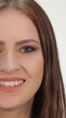 Hoş bir süveter giymiş, neşe saçan bir barış işareti gösteren çarpıcı genç bir kadın. El değmemiş beyaz bir arkaplan, onun parlak gülüşü ve davetkar tavırları bir sıcaklık ve bağlantı atmosferi yaratıyor, bir ruhu somutlaştırıyor.