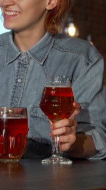 A cheerful group of friends raises their glasses filled with golden beer, celebrating friendship in a vibrant pub setting. The warm bar lights illuminate their joyful faces, creating an inviting atmosphere of laughter and camaraderie