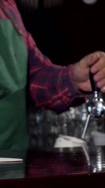 Yetenekli bir barmen bardağa altın köpüklü bir bira doldurur, kahkaha ve arkadaşlıkla dolu canlı bir barın özünü yakalar. Cilalı tezgah, ortam ışıklarının sıcak parıltısını yansıtıyor. Müşterileri bu anın tadını çıkarmaya davet ediyor.