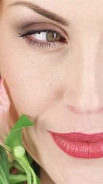 Güzel bir kadının büyüleyici yakın çekimi, dalgalı sarı saçları, narin çiçeklerle yüzünü okşaması, neşe ve zarafet saçıyor. Bu büyüleyici portre, bahar ruhunu temsil ediyor, canlı gülüşünü ve yumuşak gülüşünü sergiliyor.