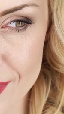 Güzel bir kadının büyüleyici yakın çekimi dalgalı sarı saçlarıyla narin çiçeklerin arasında nazikçe yüzünü okşuyor. Bu büyüleyici portre, baharın özünü yansıtıyor. Neşeli gülümsemesini ve zarafetini vurguluyor.