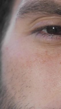 Mutlulukla parıldayan neşeli bir adamın yakın plan çekimi, ışıl ışıl gözleri ve sıcaklığı ve pozitifliği saçan büyüleyici gülümsemesi. Yumuşak güneş ışığı, onun genç özelliklerini ön plana çıkarıyor. Kaygısız özgüvenini somutlaştıran davetkar bir atmosfer yaratıyor.