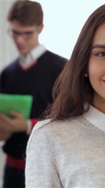 Kendinden emin esmer bir kadın ön planda sıcak gülümsemesiyle pozitiflik yayarken, odaklanmış gözlüklü beyaz bir adam ve kıvırcık saçlı bir kadın arkasında canlı yeşil bir tabletle meşgul oluyor. Bu dinamik ofis sahnesi çok güzel.