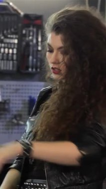 Büyüleyici bir bayan motosikletçi, parlak bir helikopterin üzerinde uzanır, şehvetli kıvırcık saçlarını, kaygısız bir güvenle arkaya atar. Şık siyah deri bir ceket ve şık bir kot şort giyen bu büyüleyici beyaz kadın cesaret ve macera saçıyor.