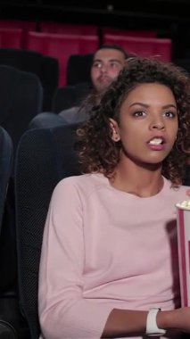 Canlı bir grup genç arkadaş, sinemanın heyecanından zevk alıyor. Samimi bir multipleks 'te, gözleri ekrana yapışık. Ellerinde patlamış mısır kovaları ve ışıl ışıl gülümsemeleriyle, kahkahalar ve neşeyi paylaşıyorlar, unutulmaz anlar yaratıyorlar.