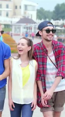 Üç şık genç arkadaş canlı bir caddede neşeyle yürüyor, kahkahaları altın güneşin altında yankılanıyor. Moda kıyafetleri içinde, yaz maceralarının ve anıların ruhunu somutlaştırıyorlar, mutluluk ve bağlantı yayıyorlar.