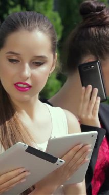 Canlı bir şehir ortamında, üç güçlü iş kadını dinamik iletişime daldırılıyor, biri telefonla, diğeri ise parlak bir tablet üzerinde işbirliği yapıyor. Şık kıyafetleri ve azimli ifadeleri canlı bir atmosfer yayıyor.