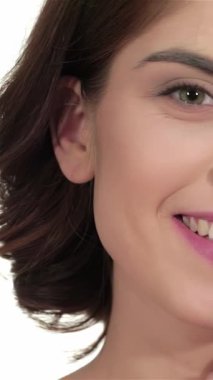 Bu büyüleyici yakın plan, pırıl pırıl ciltli, el değmemiş beyaz bir arka plana sıcak bir gülümseme saçan çarpıcı genç bir kadını gösteriyor. Taze teni ve narin özellikleri doğal güzelliğin özünü temsil ediyor. Hayranlık uyandırıyor ve ilham veriyor.