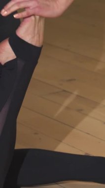 Büyüleyici bir yakın çekim, yoga pozu almış çarpıcı koyu renk saçlı bir kadın, silueti sıcak akşam ışığı tarafından güzelce aydınlatılmış. Odaklanmış bir ifade ve zarif bir esneme ile dinginliği ve gücü somutlaştırarak izleyicilere ilham veriyor.