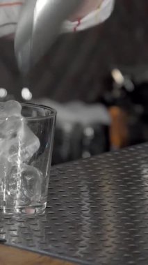 Yetenekli bir bayan barmen pırıl pırıl buz küplerinin üzerine ustaca viski dökerek miksolojinin özünü yakalar. Cilalı çelik tezgahı ve çevre aydınlatmasıyla şık bir bar ortamı mükemmel bir davetkar atmosfer yaratıyor.