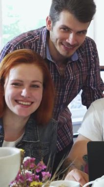 Neşeli genç yetişkinlerden oluşan canlı bir grup, cezbedici hamur işleri ve aromatik kahveyle çevrili büyüleyici bir kafede keyifli bir kahvaltı yapıyorlar. Sıcak gülüşleri ve iç açıcı konuşmaları davetkar bir atmosfer yaratıyor, bağlanmak için mükemmel.