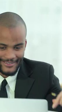 Aydınlık, modern bir ofiste, iki kendine güvenen iş adamı koyu saçlı ve diğerinin traşlı kafa paylaştığı bir dizüstü bilgisayarı incelerken neşeli bir an. Işıltılı gülümsemeleri ve çekici ifadeleri takım çalışmasının ve işbirliğinin ruhunu somutlaştırıyor.