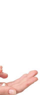 Bu yakın plan çekimde genç beyaz bir kadın nazikçe avuçlarına krem sürüyor, narin parmaklarını nazikçe hareket ettiriyor. El değmemiş beyaz arka plan yumuşak ellerini vurguluyor, rahatlamanın ve kendine bakmanın huzurlu atmosferini anımsatıyor.