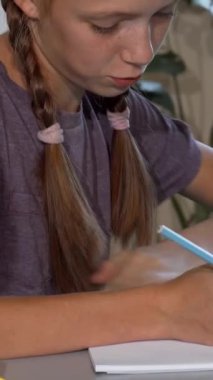 Saçları örgülü odaklanmış genç bir kız ve bir oğlan canlı bir sınıftaki parlak kalemlerle çevrili renkli sanat projeleriyle tutkuyla meşguller. Bu büyüleyici sahne, çocukluk yaratıcılığının özünü güzel bir şekilde yakalıyor.