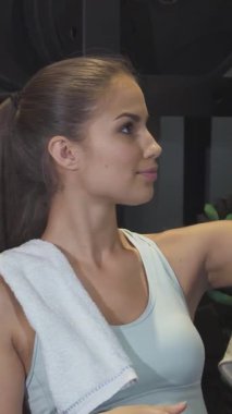 İki çarpıcı genç kadın, biri dalgalı kızıl saçlı, diğeri parlak siyah bukleli, canlandırıcı bir egzersizden sonra zevkle spor salonunda selfie çekiyorlar. Işıl ışıl gülüşleri ve şık atletik kıyafetleri, canlı bir arkadaşlık atmosferi yayıyor.