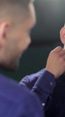 Moda bir berber dükkanında şık bir adam bakımlı sakalını okşar ve aynadaki yansımasına ışıldar. Bu büyüleyici sahne modern erkeksiliği somutlaştırıyor, tımar sanatını ve kişisel bakım ritüelini vurguluyor.