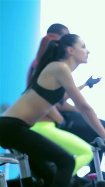 Canlı mavi tonlarla dolu canlı bir spor salonunda, atletik kızlar susuzluk çekmek için duraklarlar, güçlü fiziklerini göstererek, heyecanlı bir çalışma yaparlar. Arkadaşlar sabit motorlarda kardiyo yaparken, takım çalışmasını somutlaştırırken atmosfer enerji ile uğulduyor.