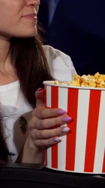 Canlı bir sinema ortamında, iki neşeli bayan arkadaş bir kova patlamış mısırı paylaşır, bir komedi filminden zevk alırken kahkahalar yankılanır. Enerjik atmosfer neşe ve dostlukla dolu. Bu da onu eğlence ve dostluk için mükemmel bir gece yapıyor.