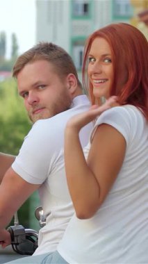 Neşeli bir çift canlı bir şehir manzarasında motosiklete biniyor ve kameraya coşkuyla el sallıyor. Işıl ışıl gülüşleri ve kaygısız tavırları yaz macerasının, aşkın ve renkli kentsel ortamın ortasındaki gençlik şenliğinin özünü yansıtıyor.