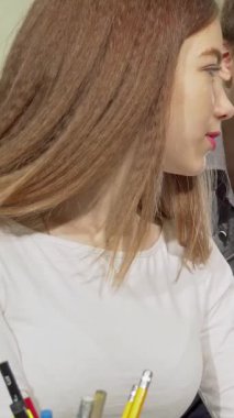 Renkli bir okul kütüphanesine dalmış iki kız ve iki oğlandan oluşan dinamik bir grup, bir dizüstü bilgisayarın etrafında hevesle iş birliği yapıyor, yüzleri heyecan ve merakla parlıyor. Bu canlı sahne, takım çalışmasının ve akademik gelişimin özünü yansıtıyor.