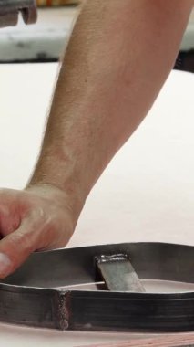 Yetenekli bir kunduracı, alet ve malzemelerle dolu canlı bir atölyede ustalığını sergileyerek, tabanları titizlikle kesiyor. Bu büyüleyici sahne, yüksek kalitede sanatçılık ve adanmışlığı vurguluyor.