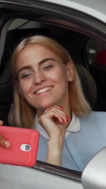 Işıl ışıl genç bir çift, güzel, gümüş renkli arabalarının içinde aşk ve heyecanın vücut bulduğu selfie çekiyorlar. Parlak gülüşü ve şık kıyafetiyle kadın arabanın anahtarlarını tutarken partneri de bu unutulmaz anı yakalayıp kutluyor.