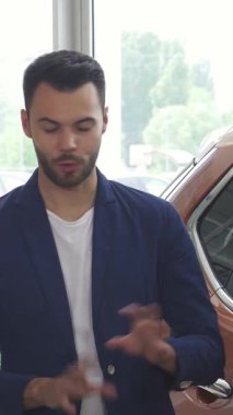 İki şık genç adam, modern bir bayilikte heyecan ve dostluk saçan çarpıcı yeni bir araba hakkında coşkulu bir sohbete girişiyor. Sergi salonu parlak araçlarla parıldıyor, araba sevenleri davet eden canlı bir atmosfer yaratıyor.