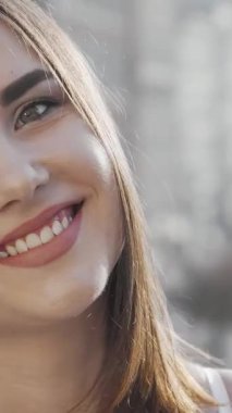 Neşeli genç bir kadın bulaşıcı mutlulukla ışıldıyor, ışıl ışıl gülüşü şehrin hareketli sokaklarına karşı sahneyi aydınlatıyor. Bu büyüleyici görüntü onun kaygısız ruhunu özetliyor. Şehir hayatının enerjisini yansıtıyor.