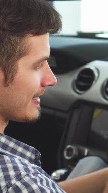 Bu yakın plan çekimde, üstü açık arabasının direksiyonunda rahatça akıllı telefonunu kullanan genç ve yakışıklı bir adam neşe saçıyor. Canlı atmosfer, özgürlüğün ve modern yaşamın özünü yakalıyor ve heyecanı vurguluyor.