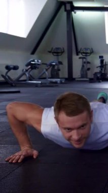 Formda bir erkek ve kadın son model ekipmanlarla dolu şık bir spor salonunda senkronize şınav çeker, güç ve kararlılık saçar. Onların kaslı fizikleri ve odaklanmış ifadeleri takım çalışmasının ve fitness 'e olan bağlılığının özünü vurgular.