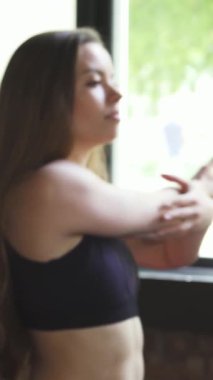 Güneşli bir spor salonunda, iki kararlı genç kadın, birinin saçları örgülü, diğerinin saçı dalgalı, kollarını zarafet ve enerjiyle uzatıyorlar. Bu canlı sahne takım çalışmasını ve motivasyonunu somutlaştırıyor. Forma ve sağlığa olan bağlılıklarını vurguluyor.