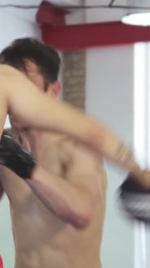 Güçlü bir kickboksör, keskin bir fiziği var, antrenmanlara odaklanarak devam ediyor ve koçlarına doğru düzgün yumruklar atıyor. Canlı spor salonu, enerji dolu ve renkli eğitim teçhizatı ile donatılmış, adanmışlık atmosferini arttırır.