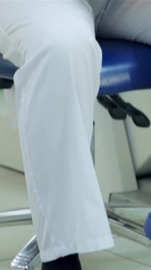 Gıcır gıcır mavi üniformalı kendini işine adamış bir dişçi hasta kayıtlarını özenle inceliyor. Gösterişli, modern bir klinikte profesyonelliği vurguluyor. Bu sahne, dişçi bakımının özünü somutlaştırıyor. Detaylara titiz bir özen gösteriyor.