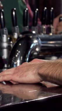 Yetenekli bir barmen soğuk bardağa köpüklü, altın bir bira dökerek neşeli bir an yaratıyor. Barın sıcaklığı ve davetkar atmosfer dostluk ve rahatlama hissini arttırır, her yudumu bir yudum yapar.