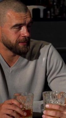 Olgun erkek arkadaşların bir bardak viski eşliğinde yürekten kahkahalar atmasıyla, şık barlarda dostlukları ışıldarken canlı bir sahne ortaya çıkıyor. Şık bir süveter giyen neşeli sakallı adam, arkadaşlarıyla hareketli bir şekilde nişanlanır.