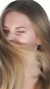 Akan sarı saçlı neşeli genç bir kadın neşeli bir şekilde gülümsüyor, parlak cildi el değmemiş beyaz bir fon üzerinde parlıyor. Parlak gözleri ve neşeli ifadesi gençliğin canlılığını, hayranlığı ve ilhamı simgeliyor.