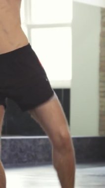 Güçlü bir keskin nişancı, kendini işine adamış bir boksörü, şık ve modern bir spor salonunda koçunun tuttuğu pedlere sert tekmeler atarak sergiliyor. Sporcular fiziği ve yoğun dikkati yonttular kararlılık ve güç yaydılar.