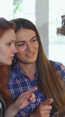 Taze pişmiş malların tatlı aromasıyla dolu sıcacık bir fırında canlı saçlı iki genç kadın lezzetli kurabiyeler arasından heyecanlı bir şekilde seçim yapıyor. Gülüşleri ve animasyon ifadeleri çok hoş bir atmosfer yaratıyor.