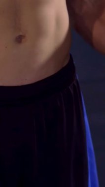 Kararlı genç bir Kafkasyalı spor salonundaki pazı egzersizine yoğun bir şekilde odaklanıyor ve heykel şeklindeki fiziğini sergiliyor. Yakın çekim, kas gövdesinin tanımını, halterlerle alternatif kıvrımlar sergileyerek yakalıyor.