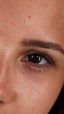 Göz kamaştırıcı bir yakın çekim kusursuz derili neşeli genç bir kadını canlı yeşil bir arkaplanda kameraya doğru ışıldarken yakalıyor. Doğal güzelliği ve tasasız ruhu, bu canlı anda kendine güvenini ve pozitifliğini gösteriyor.