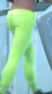 Enerjik ve atletik kıyafetleri olan iki kız, parlak, modern bir spor salonunda koşu bandında koşuyor, motivasyon ve güç yayıyorlar. Odaklanmış ifadeleri ve güçlü hareketleri aktif bir yaşam tarzının özünü somutlaştırıyor.