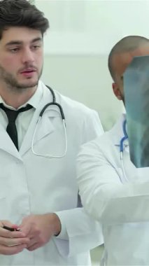 İki kendini adamış doktor, bir erkek ve bir kadın, akciğer röntgenini yakından inceleyerek, sigara içmenin ciddi sağlık risklerini tutkuyla tartışıyor. Gıcır gıcır beyaz önlükleri ve odaklanmış ifadeleri profesyonellik ve takım çalışması yayarak,