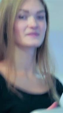 Neşeli genç bir kadın koşu bandında enerjik bir şekilde koşar, uzun saçları arkasından neşeyle ışıldarken. Modayı takip eden atletizm kıyafetleri içinde, enerjik bir jimnastik salonunda azim ve canlılık saçarak, diğerlerini,