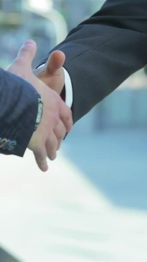 Güçlü bir ortaklığı sembolize ederek sıkı sıkıya tokalaşan iki iş adamının yakın çekimi. Canlı kentsel zemin enerji yayıyor, işbirliği atmosferini ve karşılıklı başarıyı arttırıyor, heyecanı yakalıyor.