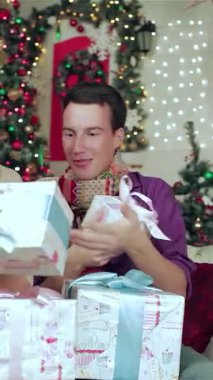 Hoş kazaklara ve renkli eşarplara sarılı neşeli bir çift, büyüleyici bir şekilde dekore edilmiş bir Noel odasında güzel paketlenmiş hediyeleri açıyor. Işıldayan ışıklar ve görkemli bir Noel ağacı ile çevrili, onların ışıl ışıl gülümsemeleri ve