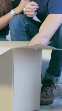 Neşeli bir çift, neşe saçıyor, yeni dairelerinde paketsiz kutularla çevrili rahat beyaz bir kanepeye yakın oturuyorlar. Sıcak gülümsemeleri ve şefkat dolu kucaklamaları birlikte yeni bir yolculuğa çıkmanın heyecanını özetliyor, boş olanı dönüştürüyor.